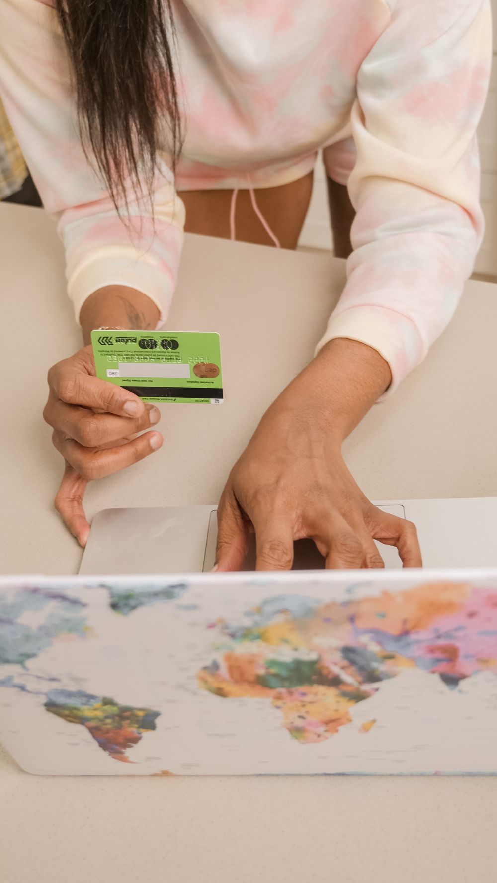 An adult using a credit card for online shopping on a laptop.
